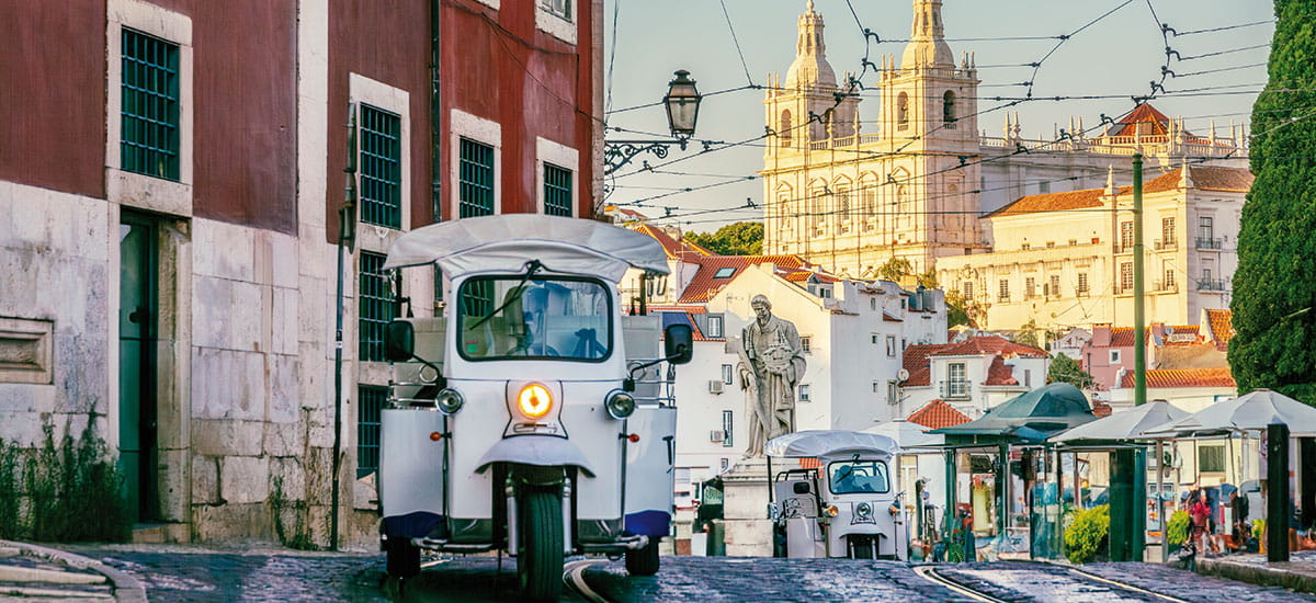 A vintage tram driving down a street in Lisbon, Portugal